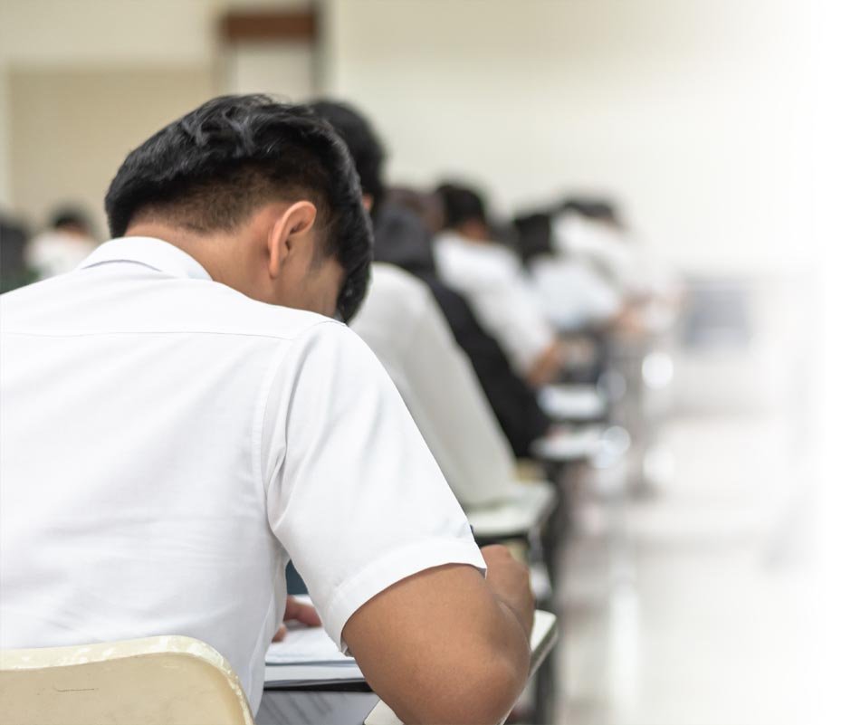 School student exam in university class with blurry view from back of the classroom of young people having stress doing examination admission test in classroom for education background